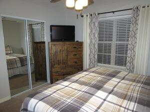 een slaapkamer met een bed en een flatscreen-tv bij Lakefront Condo A-1 with Large Balcony in Hollister