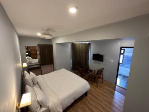 um quarto com uma cama, uma mesa e uma cadeira em Hotel Apricot Inn kargil em Kargil