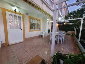 d'une terrasse avec une porte blanche, une table et des chaises. dans l'établissement Apartamento bajo con terraza y piscina, à Torrevieja