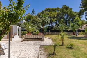 een tuin met een bank en bomen in een tuin bij Villa Soleanna Residence in Vieste