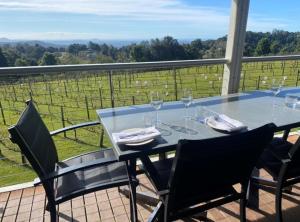 a table with wine glasses and chairs on a balcony at Flame Hill Vineyard in Montville