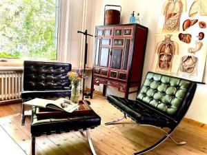 een woonkamer met 2 lederen stoelen en een tafel bij Agelandkaai (.be) Free Parking in Gent