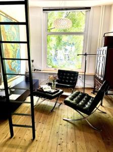 a room with chairs and a table and a window at Agelandkaai (.be) Free Parking in Ghent