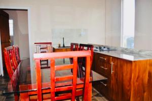 una cocina con sillas rojas y una mesa con barra en Channa villa, en Nuwara Eliya