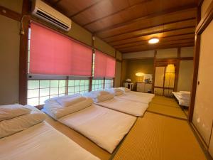 a group of four beds in a room with a window at Naoshima J-House in Naoshima