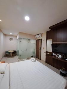 a bedroom with a large white bed and a table at Hotel Morena Batam in Batam Center