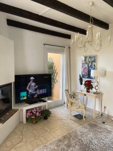 een woonkamer met een flatscreen-tv en een tafel bij Villa Lucie in Valbonne