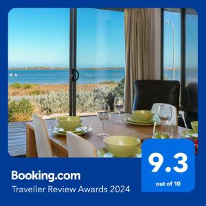 a table with wine glasses and a view of the ocean at Absolute Waterfront Views and Kayaks in Meningie