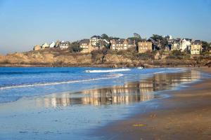 a view of a beach with houses on a hill at Appartement 1 chambre terrasse 200m de la plage et GR34 in Saint-Lunaire