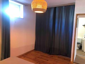 a room with a black curtain and a chandelier at Appartement 1 chambre terrasse 200m de la plage et GR34 in Saint-Lunaire