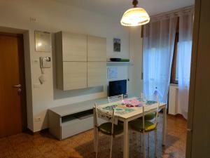 a kitchen with a glass table and two chairs at La Casa dei Cipressi in Belluno