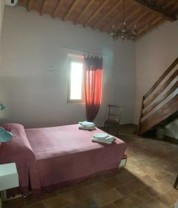 1 dormitorio con cama con sábanas rosas y ventana en Agriturismo Fattoria le caprine en Gambassi Terme