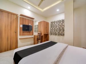 um quarto com uma cama branca e uma televisão em Collection O Zamzam Residency em Bhopal