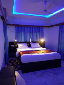 a bedroom with a large bed with a blue light at Royalwood City Inn in Birātnagar
