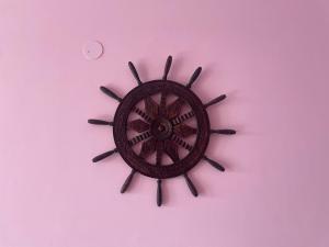 a brown clock on a pink background at Notting Hill House Home Stay Shimla in Shimla