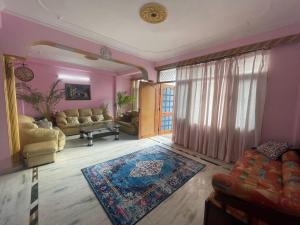 een woonkamer met roze muren en een bank bij Notting Hill House Home Stay Shimla in Shimla