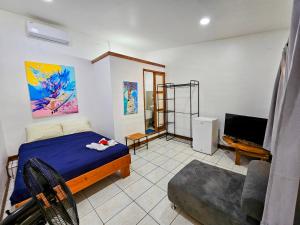 a bedroom with a bed and a tv and a couch at Santa Toro in Santa Teresa Beach