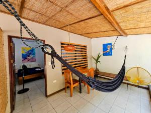 a room with a hammock and a dining room at Santa Toro in Santa Teresa Beach