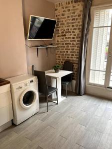 sala de estar con lavadora y mesa en 5min from Paris / Cosy Appartment, en Levallois-Perret