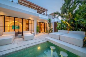 a villa with a swimming pool and a house at Casa Dala Canggu in Canggu
