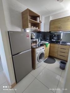 a kitchen with a refrigerator and a washing machine at MrK Penthouse at Timurbay in Kuantan