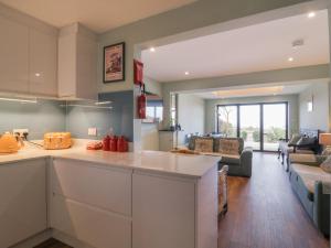 uma cozinha em plano aberto e sala de estar com um sofá em Coastguards View em Herne Bay