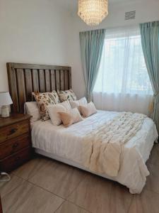 um quarto com uma cama com almofadas e uma janela em El Seuno de África -The dream of Africa em St. Lucia