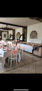 a dining room with tables and chairs with white tablecloths at Хотел-ресторант Шипка,връх Шипка in Prevala