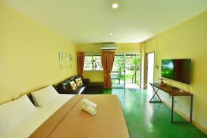 a living room with a bed and a flat screen tv at BaanSuanklaiKlungBangkrachao บ้านสวนใกล้กรุงบางกะเจ้า in Phra Pradaeng