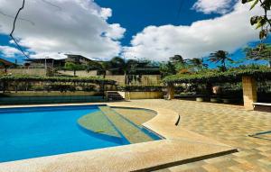 einen Pool mit blauem Wasser im Hof in der Unterkunft OYO 1067 Villa Sofia At Silang in Tagaytay