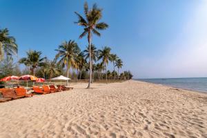 una playa con sillas, palmeras y el océano en Hana Hotel Sonasea Night Market Phu Quoc en Phu Quoc