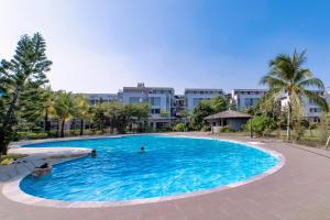 una gran piscina con gente en ella con edificios en el fondo en Hana Hotel Sonasea Night Market Phu Quoc en Phu Quoc