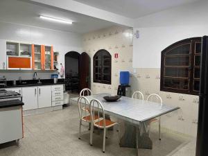 een keuken met een tafel en stoelen. bij Estância Zuliani in Guriri