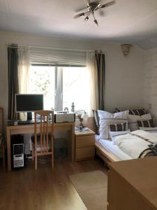 1 dormitorio con 1 cama y escritorio con ordenador en Weltevree, en Tegelen