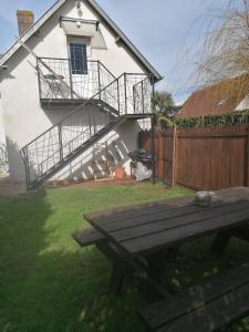 una mesa de picnic de madera frente a una casa en NATURAL COSY en Honfleur