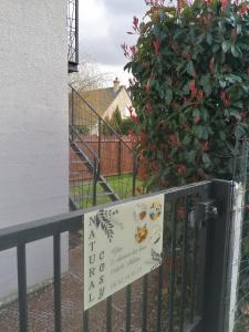オンフルールにあるNATURAL COSYの植物の前の柵の看板