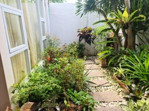 a garden with plants on the side of a house at Mimosa Villa 4 bedroom di Nusa Dua in Nusa Dua