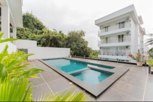 a swimming pool in front of a building at Luxury Apartments with Swimming Pool near Candolim Beach in Candolim