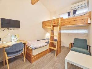 糸島市にあるItosima Guesthouse TOMOのデスク、二段ベッドが備わる小さな客室です。