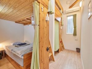 - une chambre avec un lit et un mur en bois dans l'établissement Itosima Guesthouse TOMO, à Itoshima