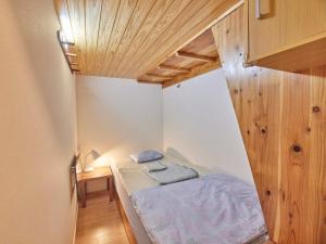 - une petite chambre avec un lit et un plafond en bois dans l'établissement Itosima Guesthouse TOMO, à Itoshima