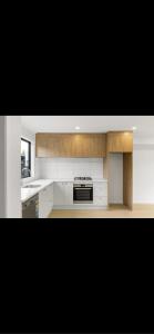 uma cozinha com armários brancos e um forno com placa de fogão em Hamilton New Town House em Hamilton