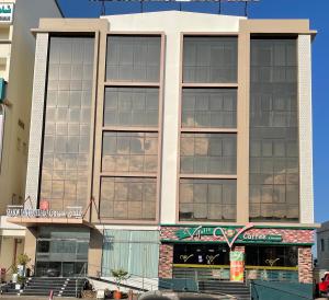 a large building with many windows on a street at Season Inn Hotel in Barka