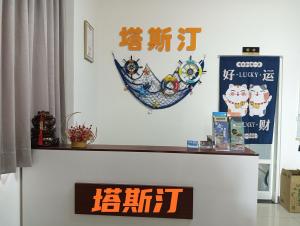 une étagère avec un signe sur un mur dans l'établissement 塔斯汀精品民宿, à Jinning