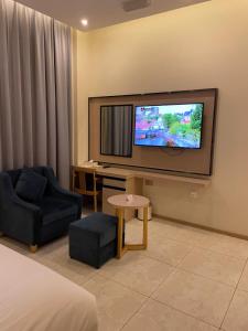 a hotel room with a tv and a couch and a chair at Season Inn Hotel in Barka