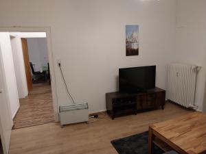 ein Wohnzimmer mit einem Flachbild-TV und einem Tisch in der Unterkunft 3 Zimmer Monteurwohnung 1 Etage in Riedstadt