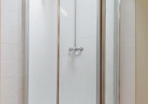 a shower stall with a glass shower door at The Cart Lodge in Erpingham