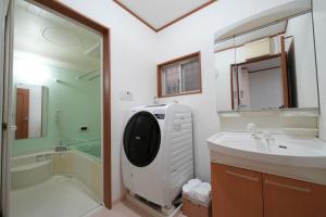 een badkamer met een wastafel en een wasmachine bij 京都佳月民宿 in Kyoto