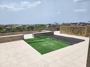 a patio with a green lawn on top of a building at Paradigm Court - TseAddo Near Cantonments and Labone in Accra