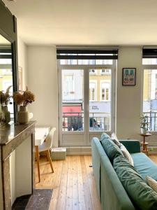 ein Wohnzimmer mit einem blauen Sofa und einem Fenster in der Unterkunft Appartement lumineux et cosy au cœur de Lille in Lille